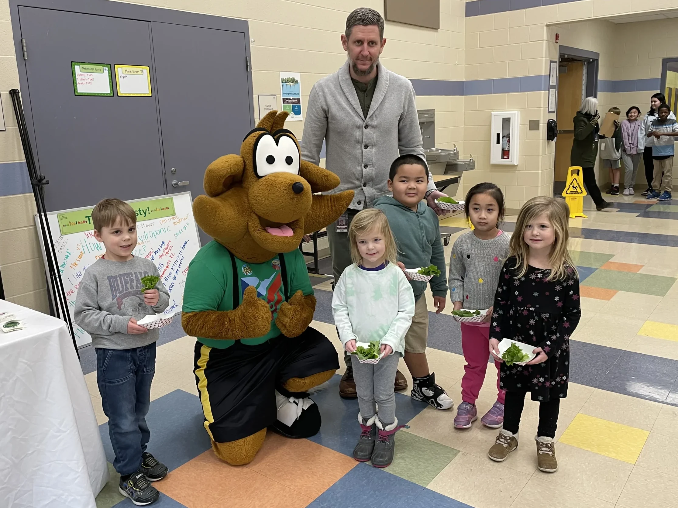 Young children meeting mascot at Totally Tasty event